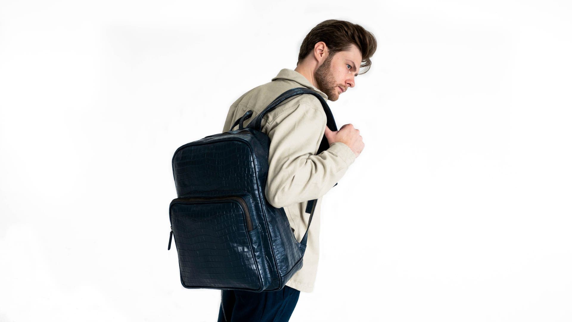A leather backpack against a warm neutral background