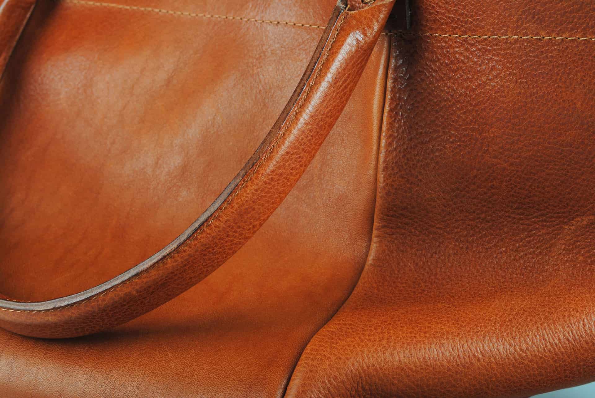 A leather tote bag standing in soft natural light
