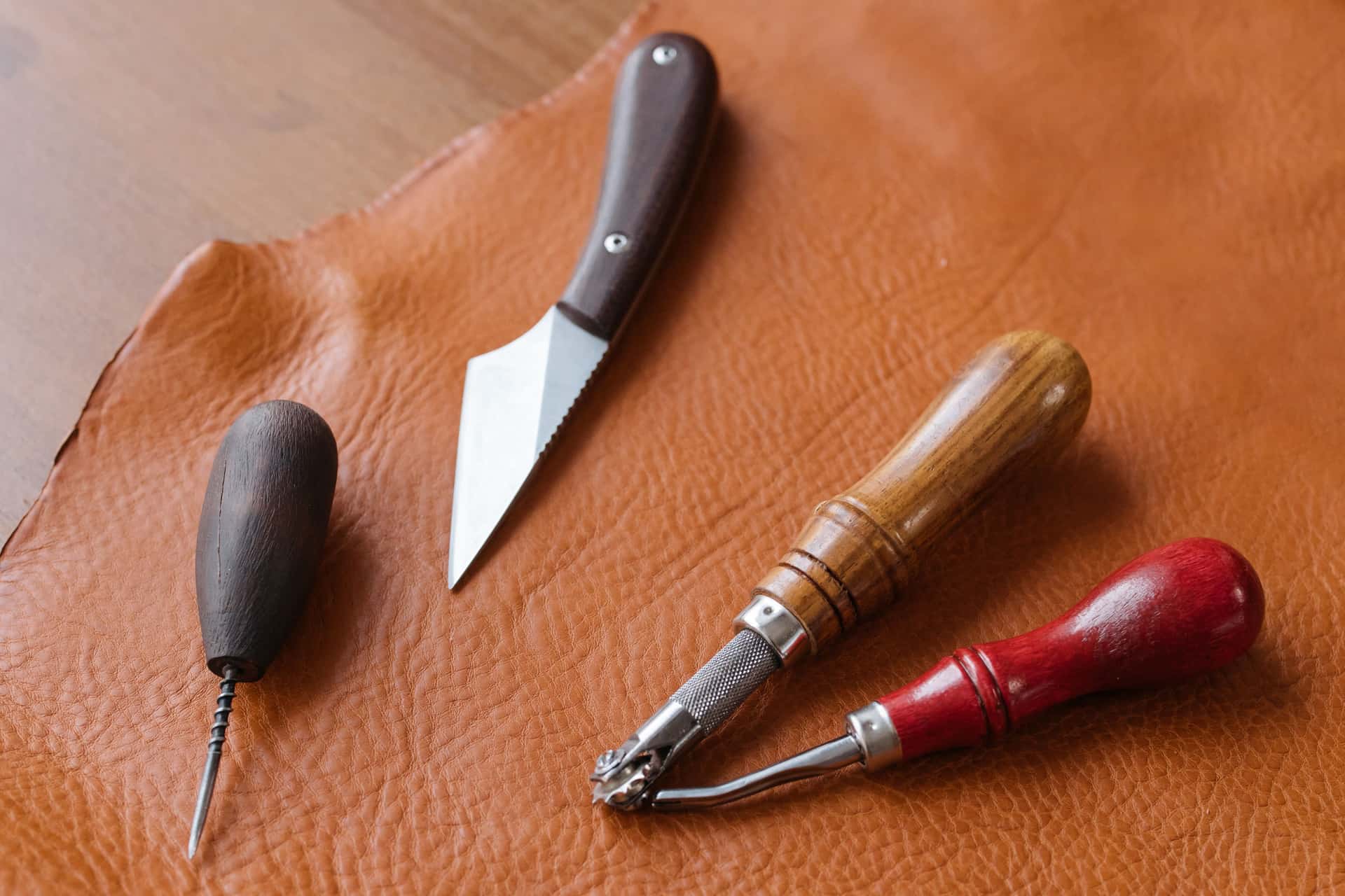 Leather hides and hand tools on a craftsman's workbench
